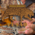 Imagem ilustrativa exibindo a garrafa da cachaça Fusão, sendo servida em um copo baixo. Sobreposto com a arte do rótulo da garrafa de cachaça.